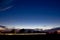 Headlights of a car driving on a country road during sunset, long exposure