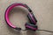 Headphone black and pink isolated on light cloth flat copy space background. Modern technology, trendy entertainment, gadget