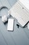 Headphone, Laptop, smartphone and microphone on grey wooden background. Remote work, Office Workplace concept. Top view