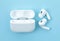 Headphones Apple Air Pods Pro 2 with Wireless Charging Case on blue background, top view. AirPods are wireless Bluetooth earbuds