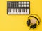 Headphones, coffee and music mixer on yellow background. The concept of workplace organization.