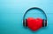 Headphones and heart shape listening music on blue wooden background, earphone with audio radio