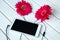 Headphones made frome gerbera flowers and smart phone on wooden table