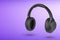 Headphones on a purple background. Wireless headphones in black, high quality, for advertising or product catalog.