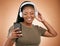 Headphones, smartphone and black woman isolated on studio background for music streaming, dance and happy. Smile of