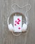 Headphones and smartphone with petals of pink rose on white screen against wooden background