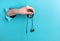 Headphones in a woman`s hand on a blue background with a hole