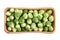 The heads of Brussels sprouts are randomly placed in a cardboard box. Box isolated on a white background.. Closeup.