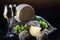 Heads of hard homemade cheese and green grapes on a dark background. Cheese and two glasses of white wine. The concept of still