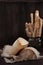 Heads of hard homemade cheese on a linen napkin on a dark background. Bread sticks in a vintage vase.The concept of still life.