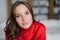 Headshot of attractive healthy European woman with dark hair and soft skin, looks directly at camera, wears warm red sweater, mode