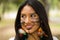 Headshot beautiful Amazonian woman, indigenous facial paint and earrings with colorful feathers, posing happily for