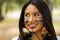 Headshot beautiful Amazonian woman, indigenous facial paint and earrings with colorful feathers, posing happily for