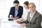 Headshot of business woman at negotiation. Group of business people discussing questions at meeting in modern office