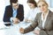 Headshot of business woman at negotiation. Group of business people discussing questions at meeting in modern office