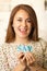 Headshot charming brunette woman holding up small letters spelling the word say and smiling to camera