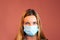 Headshot close up of a young white woman in medical mask against solid color copy space background