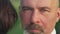 Headshot confident man looking at camera standing with unrecognizable woman outdoors. Close-up portrait of Caucasian