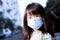 Headshot of cute girl wearing medical face mask to prevent dust PM2.5 and coronavirus outbreak when outside the house.