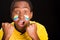 Headshot dark skinned male wearing yellow football shirt in front of black background, flag facial paint, facing camera