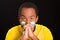 Headshot dark skinned male wearing yellow football shirt in front of black background, flag facial paint, facing camera