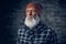 Headshot of elderly hipster dressed in plaid shirt and cap