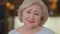 Headshot of excited smiling happy senior woman posing indoors looking at camera. Close-up front view portrait of