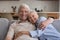 Headshot family portrait smiling senior husband wife cuddling on sofa