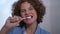 Headshot front view of cute boy brushing teeth and looking at camera with toothy smile. Close-up portrait of charming