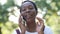 Headshot happy African American smiling woman talking on phone in sunrays outdoors. Close-up portrait joyful beautiful