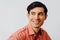 Headshot hispanic latino man black hair smiling handsome young adult wearing melon shirt over gray background looking