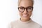 Headshot of hopeful dreamy attractive elegant woman in trendy glasses with combed hair smiling looking friendly and