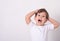 Headshot of impressed attractive little boy opening mouth from amazement and shock holding hands near face