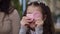 Headshot joyful Middle Eastern girl having fun in seafood restaurant resting with family playing with shrimp chips