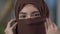 Headshot of joyful pretty Middle Eastern woman with brown eyes opening face covered with hijab headscarf. Close-up face