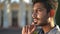 Headshot of pensive Middle Eastern young man looking away thinking standing outdoors. Close-up side view portrait of