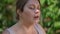 Headshot of perspiring plus-size sportswoman wiping sweat off face in slow motion looking away. Close-up portrait of