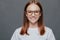 Headshot of pleasant looking dark haired young woman wears transparent glasses, dressed in casual clothes, has healthy skin,