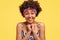 Headshot of pleased touched young African American woman smiles gently, feels pleased, wears striped top and headwear