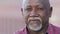 Headshot portrait of citizen serious pensive black male with wrinkles looking at camera closeup, friendly grandfather