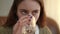 Headshot portrait of depressed stressed adolescent girl drinking water looking away. Close-up Caucasian teenager indoors