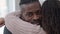 Headshot portrait of happy African American father hugging teen daughter looking at camera smiling. Close-up of handsome