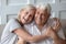 Headshot portrait of happy elderly couple embracing