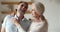 Headshot portrait of happy mature spouses laughing, talking standing indoor