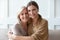 Headshot portrait of mature mom and adult daughter posing