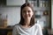 Headshot portrait of smiling millennial woman posing at home kit