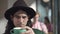 Headshot portrait of stylish retro man with long hair in hat smelling and drinking freshly brewed coffee from cup. Close