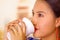 Headshot pretty young woman wearing traditional andean blouse, drinking coffee from white mug