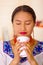 Headshot pretty young woman wearing traditional andean blouse, drinking coffee from white mug