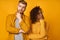 Headshot of puzzled ginger husband and his African American wife hold chin and purse lips, looks with hesitation at